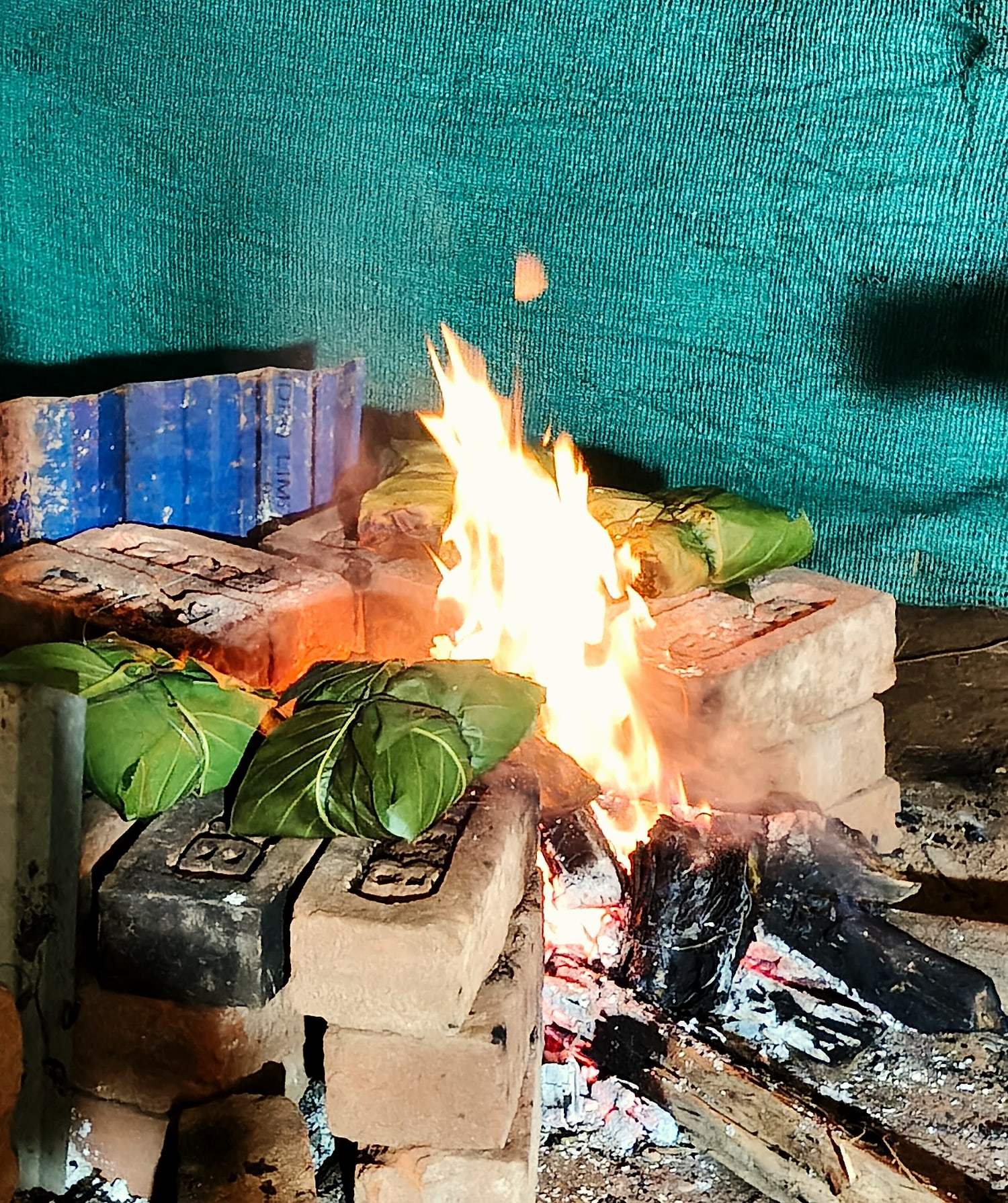 Food parcels cooking over a wood fire