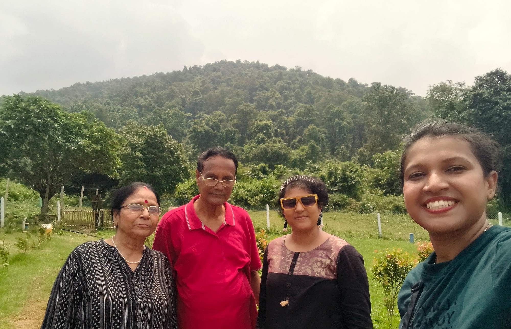 Travellers smiling for a selfie with forested hills behind them