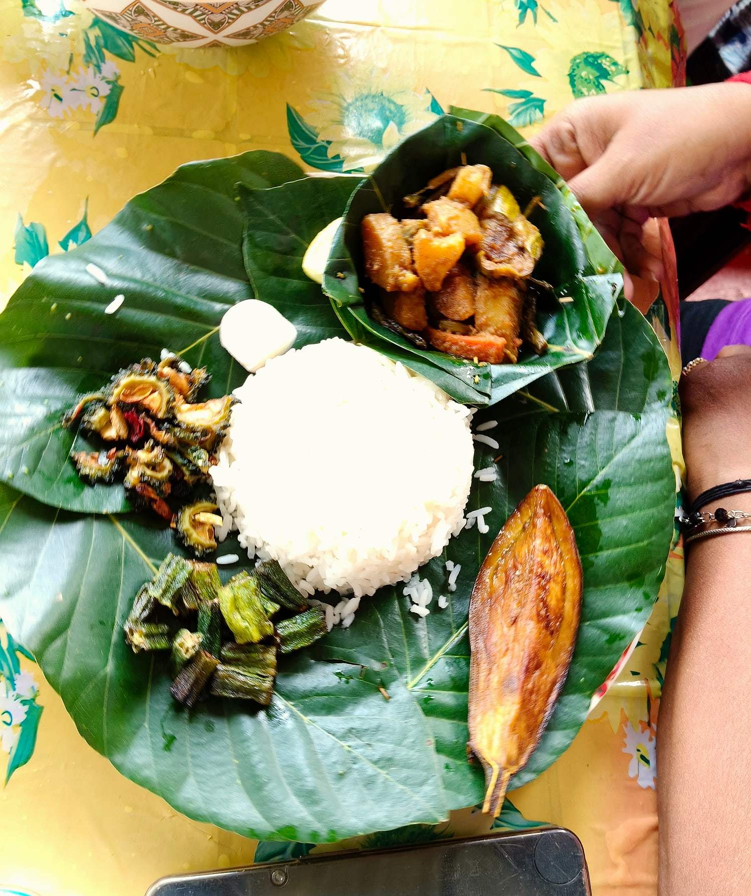 Rice, fish and fritters served on a banana leaf